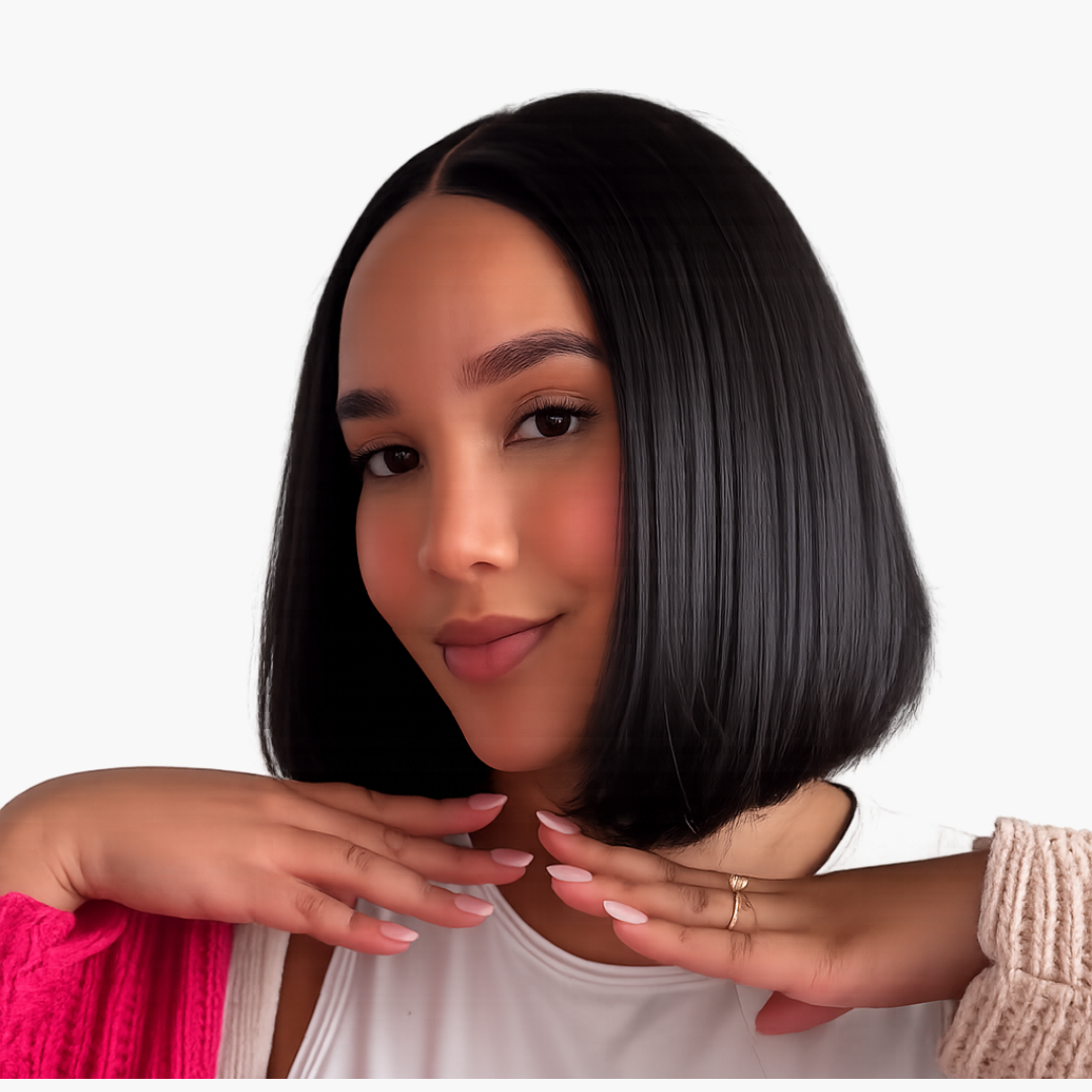 Portrait of a woman with a sleek black bob resting her chin on her hands with pink nails visible
